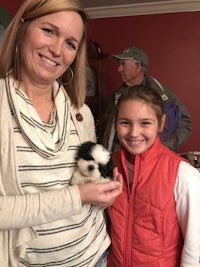 a woman is holding a small guinea pig